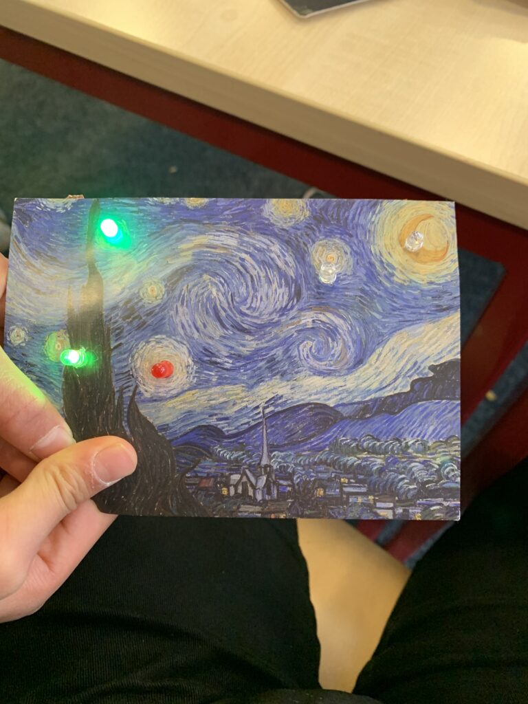 Postkarte mit Sternennacht-Motiv mit leuchtenden LEDs.