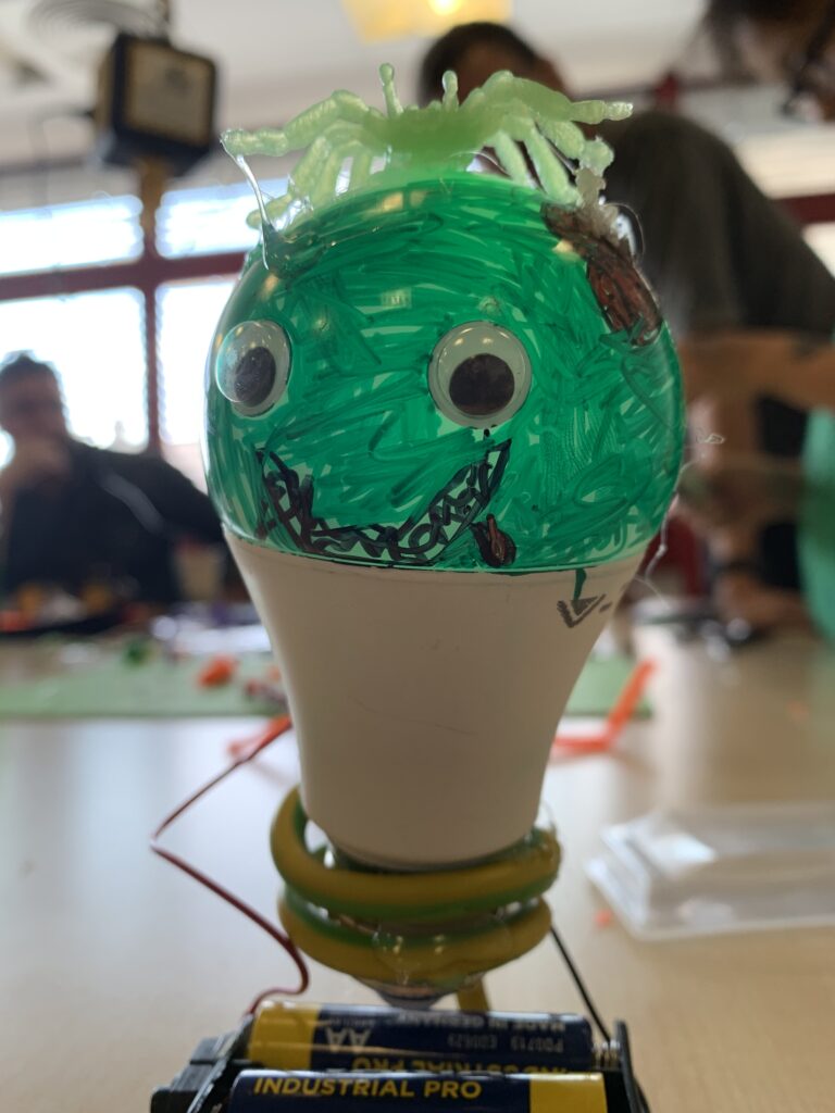 Glühbirne bemalt und gebastelt, sieht aus wie Zombie. Stromversorgung mit Batterien.